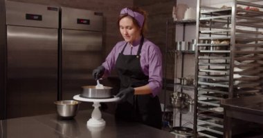 Confectioner decorates the cake. In the kitchen