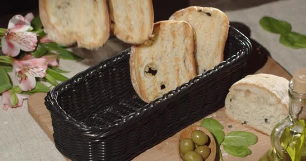 Put fresh toasters in a basket on a table decorated with a bouquet of flowers — Vídeo de Stock