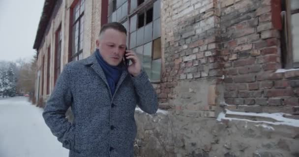 Un hombre camina por las viejas calles y habla por celular. — Vídeos de Stock
