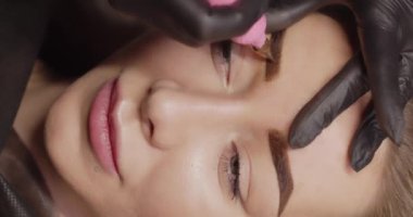 Profesyonel dövme aletleri kaş bölgesine uygulanır. Güzel kız. Yaklaş.