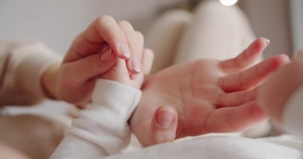 Il bambino tiene il dito di sua madre con le sue maniglie — Video Stock