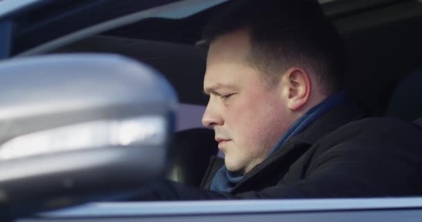 Un hombre sentado en el coche hablando por teléfono móvil — Vídeos de Stock