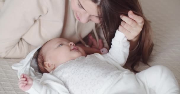Uma jovem mãe fala suavemente com seu bebê — Vídeo de Stock