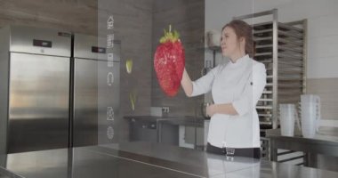 Mutfaktaki şef internetten sebze almak için şeffaf bir holografik fütüristik ekran kullanıyor.
