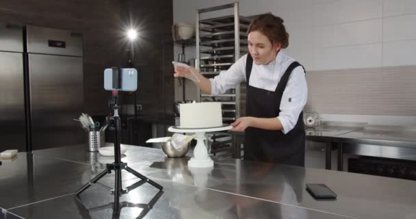 Profesionální cukrář diriguje mistrovskou třídu, vypráví a ukazuje, jak zdobit dort — Stock video