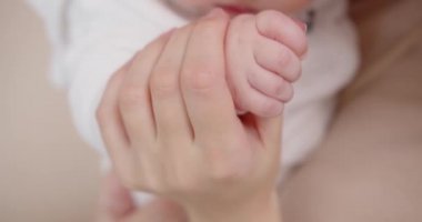 Yeni doğmuş bir bebek küçük kalemiyle bir annenin parmağını tutar.