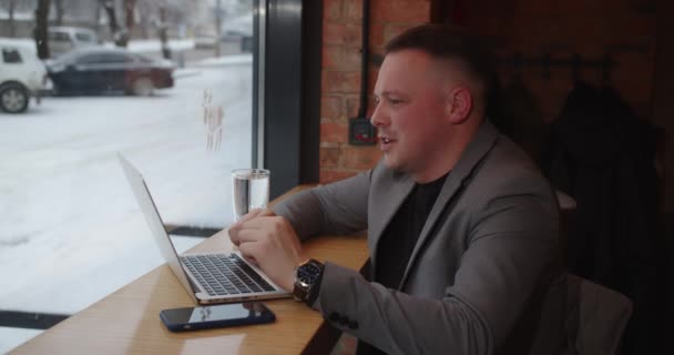 オンライン通信。カフェに座っている男が仕事の瞬間を決める — ストック動画