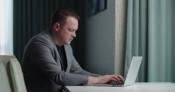 Konzentrierter Mann auf der Suche nach Informationen im Internet auf einem Laptop — Stockvideo