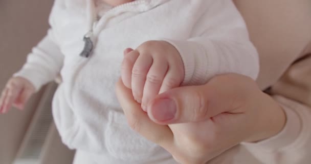 Mam streelt zachtjes de babys kleine pen — Stockvideo
