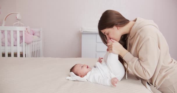 愛情のある母親が赤ん坊の足にキスをする。母方の愛. — ストック動画