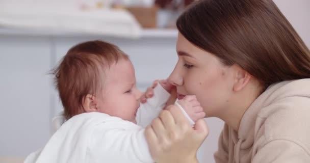 Заботливая мать играет со своим новорожденным ребенком — стоковое видео