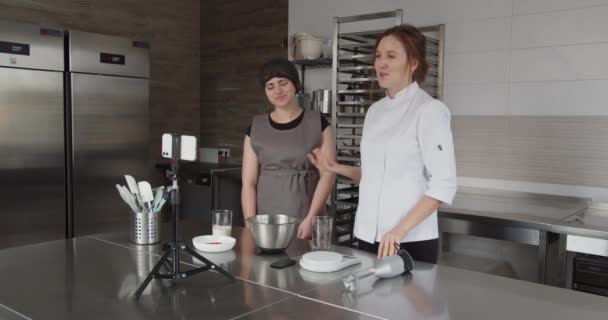 Šéfkuchař diriguje mistrovskou třídu a vypráví recept ve svém video blogu se svou asistentkou — Stock video