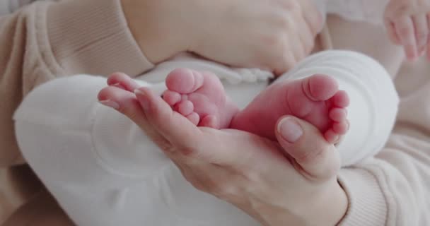 Mãe acaricia suavemente as pernas minúsculas de seu bebê — Vídeo de Stock