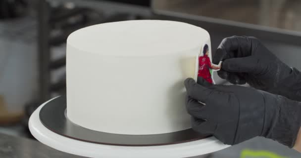 Профессиональный кондитер украшает праздничный торт — стоковое видео