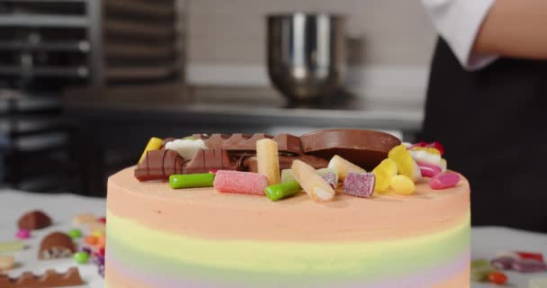 O confeiteiro decora o bolo de férias com doces doces — Vídeo de Stock