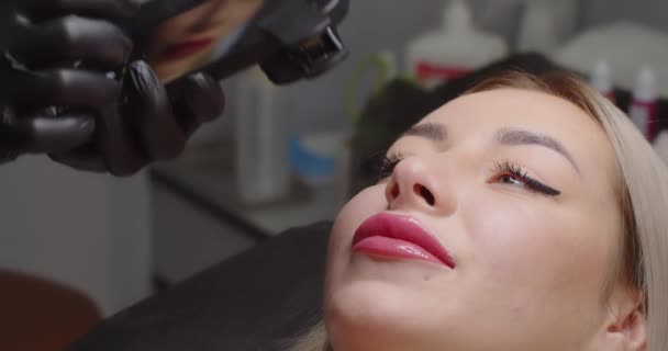 Das Mädchen mit dem Handy fotografiert das Gesicht der Kunden in einem Schönheitssalon — Stockvideo