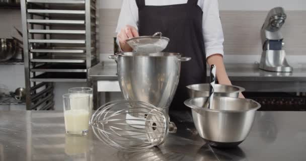 Кондитер просеивает муку в специальный контейнер для десерта — стоковое видео