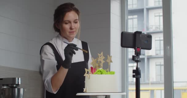 A professional confectioner conducts a master class, telling and showing how to decorate a dessert — Stock Video
