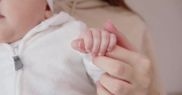 Новорожденный ребенок держит свою мать за руку. Уход за ребенком — стоковое видео