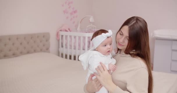 Mom holds and caresses her newborn baby in the room in the morning. The concept of motherhood — Stock Video
