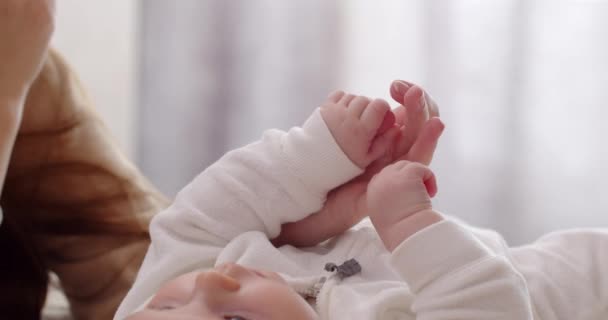 Um bebê recém-nascido segura a mão de suas mães. Cuidados com o bebê — Vídeo de Stock