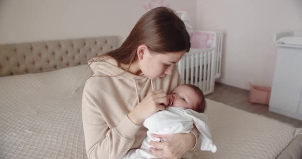 Cuidar madre arrulla bebé en sus brazos — Vídeo de stock