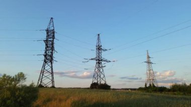 Mavi gökyüzünün arka planında elektrik direkleri