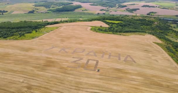 Traktor třepetal Inscription na pšeničné pole až do Dne nezávislosti Ukrajiny — Stock video