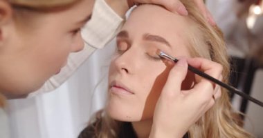 Makyöz, Göz Gölgesi 'ni fırçayla uyguluyor. Yüksek kalite 4k görüntü