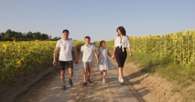 a family walks along a field path, admiring the beauty of nature