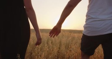 Couple in love holding hands against the background of the sun. Close up. High quality 4k footage