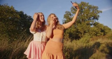 two blondes are photographed in nature on a sunny summer day