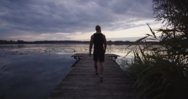Man doing yoga on the beach. A man with an athletic body goes to an evening workout
