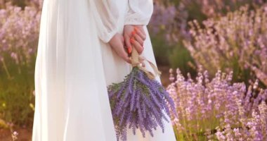 the girl holds a bouquet of lavender flowers in her hands