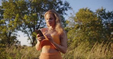 a beautiful sexy blonde is texting on the phone