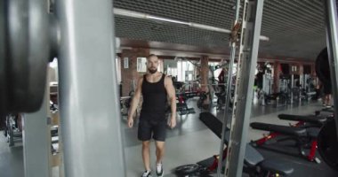 A man is pumping arm muscles on a horizontal bar in the gym. Attractive male appearance. Muscle enlargement. Proper nutrition