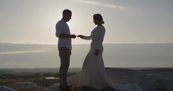 陽気な男と女の結婚指輪を屋外に置く 幸せなカップルは山の中でリングを交換します 花嫁と新郎は山の中で彼らの結婚式を祝うクローズアップ — ストック動画