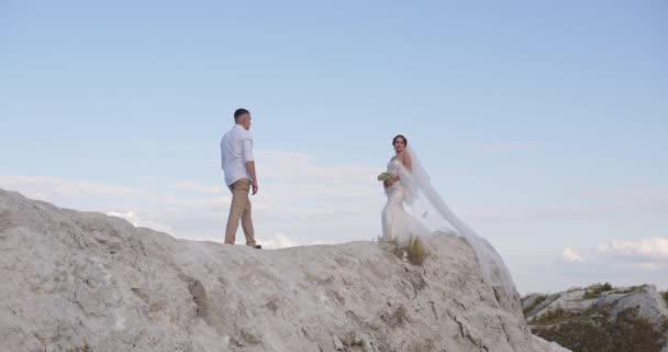 陽気な男と女が屋外を歩く 幸せなカップルは 山の中で写真を撮っている 花嫁と新郎は山の中で結婚式を祝う — ストック動画