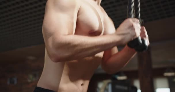 男性のボディビルダーは 体重計で動作する彼の胸の筋肉を訓練します 暗いジムの男はスローモーションで重い体重で運動をします トレーニングとボディビルディングのスポーツコンセプト — ストック動画