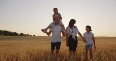 Sahada dost bir aile yürüyor ve birbirleriyle iletişim kuruyorlar.