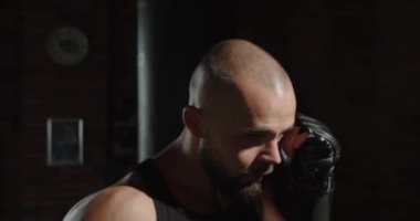 Boks eldivenli bir sporcu spor salonunda antrenman yapıyor. Dövüş için hazırlanıyor.