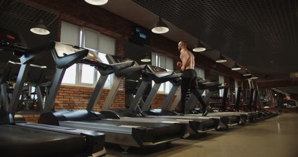 英俊的运动员在跑步机上锻炼 而独自在健身房锻炼 健康的生活方式 运动和运动 — 图库视频影像
