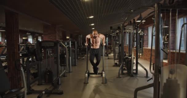 健美的男人通过在健身房做伸展运动来锻炼肌肉 赤身裸体 一个强壮英俊的运动男子 仰卧起坐肌肉训练 健身及健美 — 图库视频影像