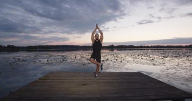 Bir insan omurga kaslarını gerer. Sahilde yoga.