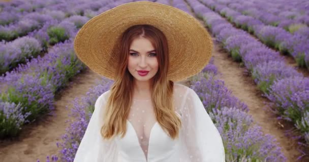 セクシーな魅力的な女の子で繊細な白いドレスは花のフィールド上を歩く — ストック動画