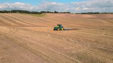 Bir traktör tarlayı sabanla geçiyor. Tarım arazileri. Tarım