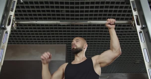 一名男子正在健身房的一个横杠上做力量锻炼 以改善自己的身体 有氧训练力量演习 锻炼肌肉 — 图库视频影像
