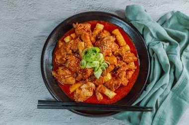 Kore yemeği Baharatlı Karıştırılmış Kızarmış Tavuk tteokbokki siyah tabakta