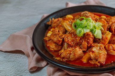 Kore yemeği Baharatlı Karıştırılmış Kızarmış Tavuk tteokbokki siyah tabakta