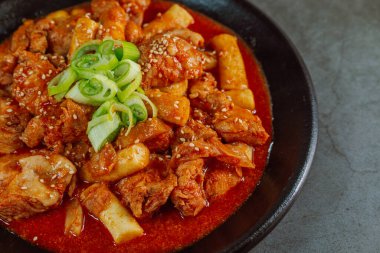Kore yemeği Baharatlı Karıştırılmış Kızarmış Tavuk tteokbokki siyah tabakta